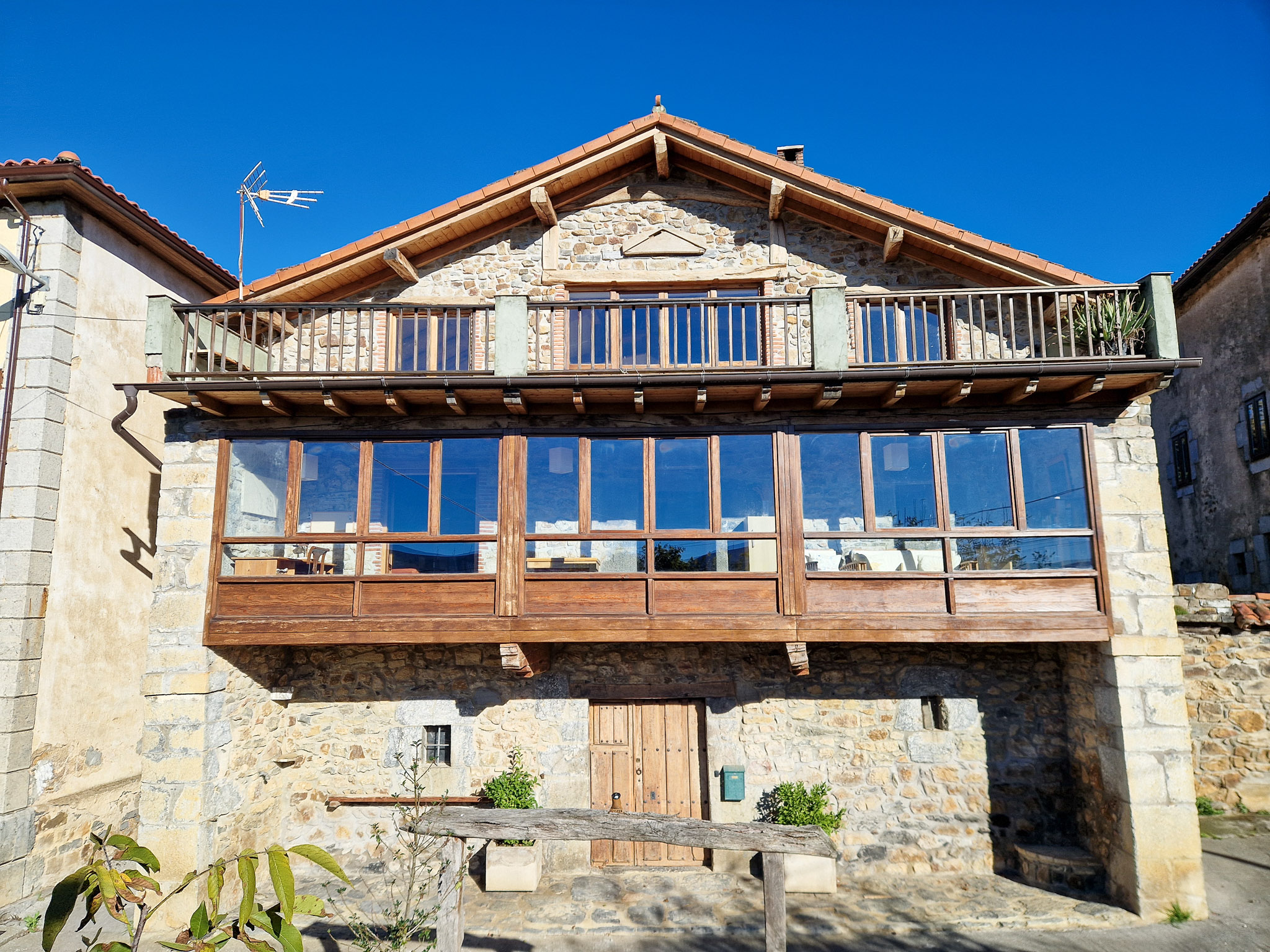 South elevation of Casa de Aja with glazed mirador and upper wooden balcony
